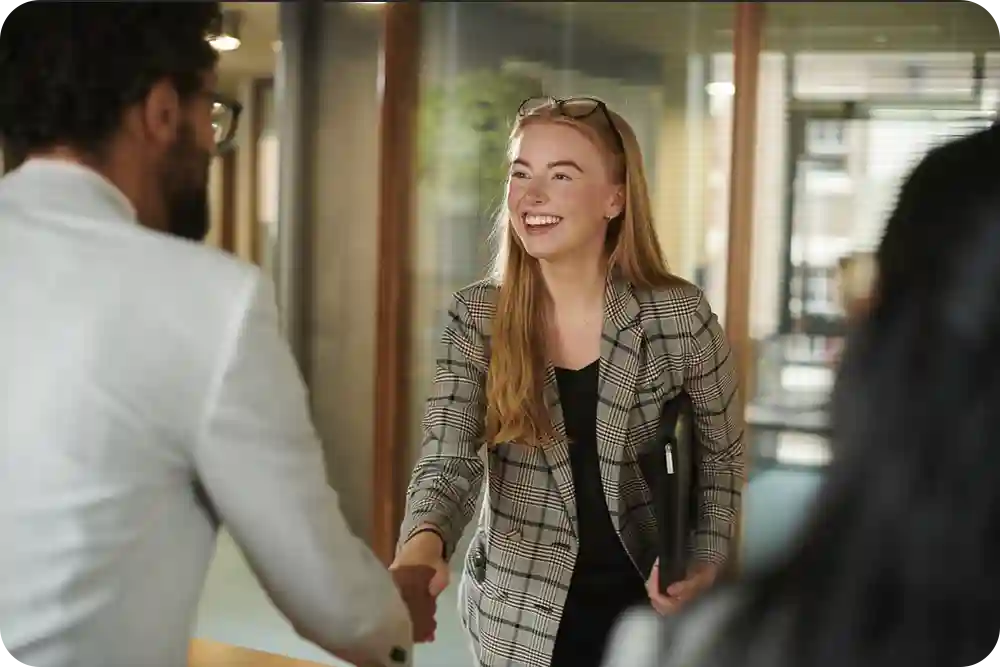 A woman shaking hands with a man.