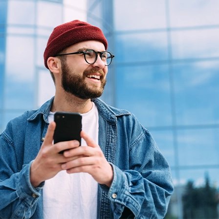 Person standing outside in the city holding smartphone