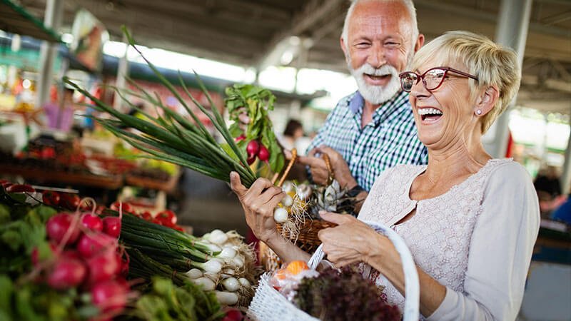 Affluent couple browsing vibrant, locally grown flowers at a market