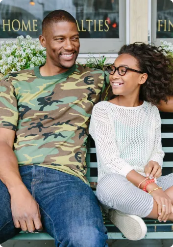 Dad and his daughter relaxing on a bench in an outdoor shopping setting