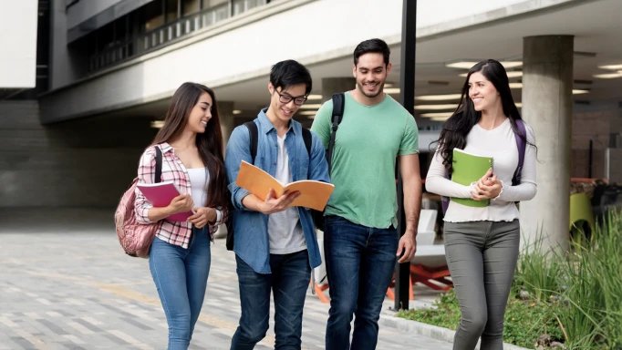 Three college students walking through campus