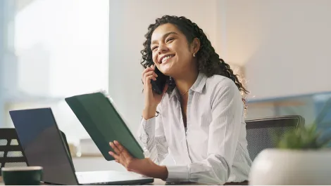 Smiling young woman talking to a financial advisor on the phone